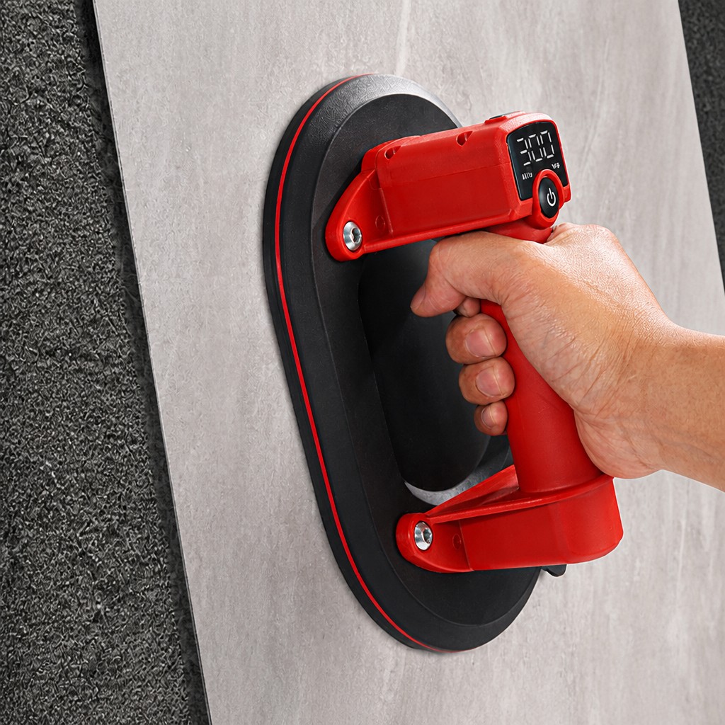 Operator carrying a large tile with the hand-held vacuum lifter